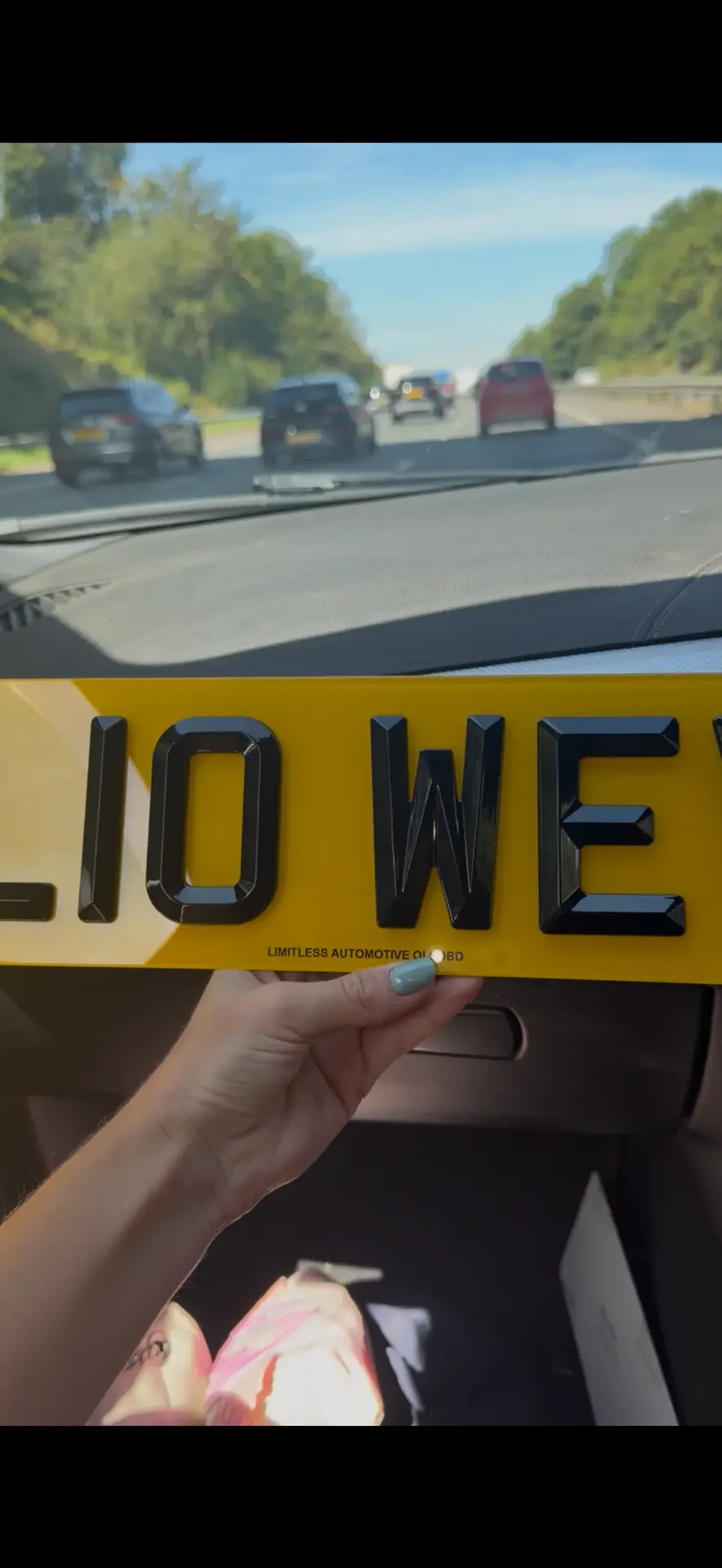 Close-up of a yellow 4D number plate with raised black lettering